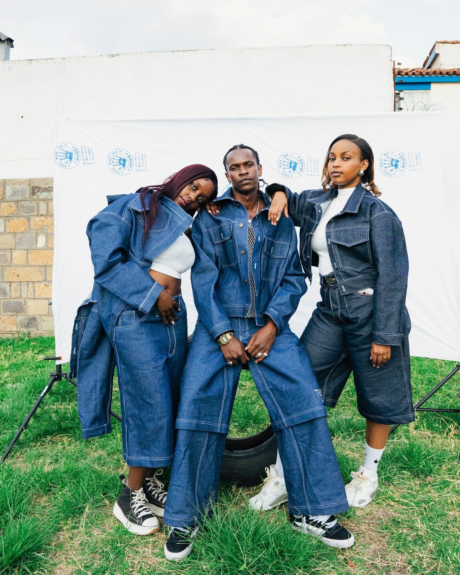 Three friends standing together in matching denim outfits