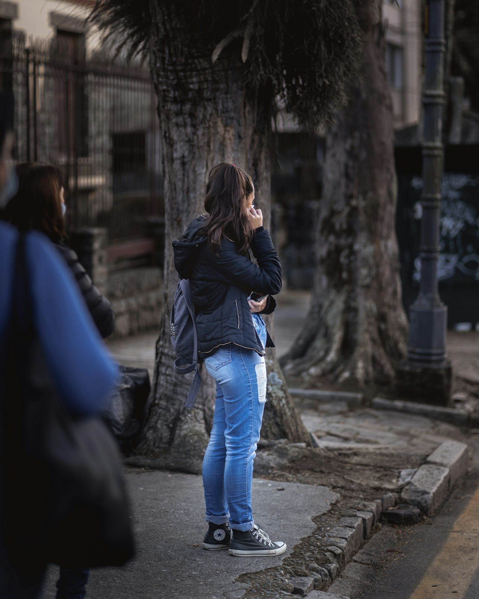 A woman walking in blue denim jeans and a jacket