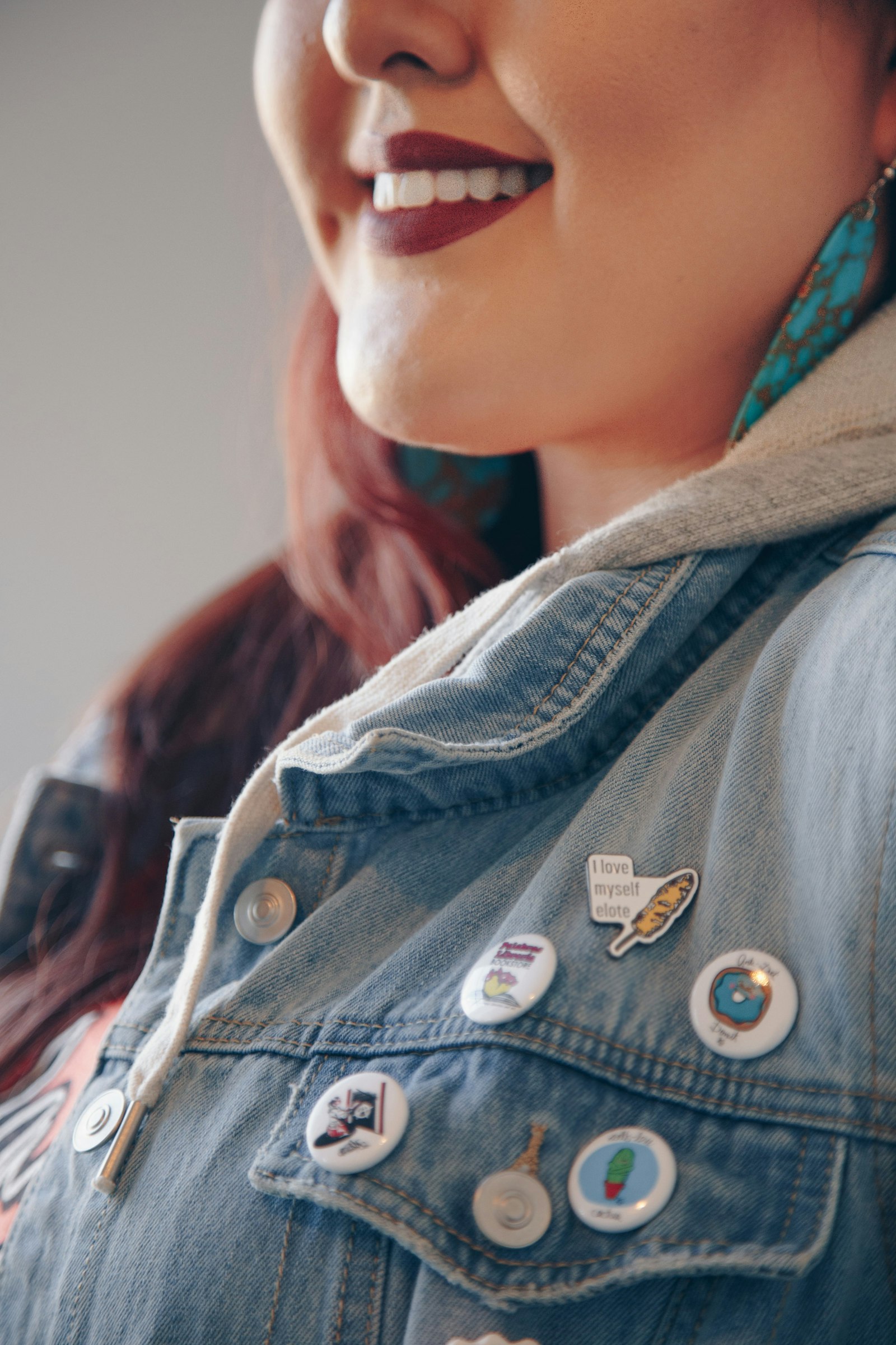A smiling woman in a blue denim collared shirt