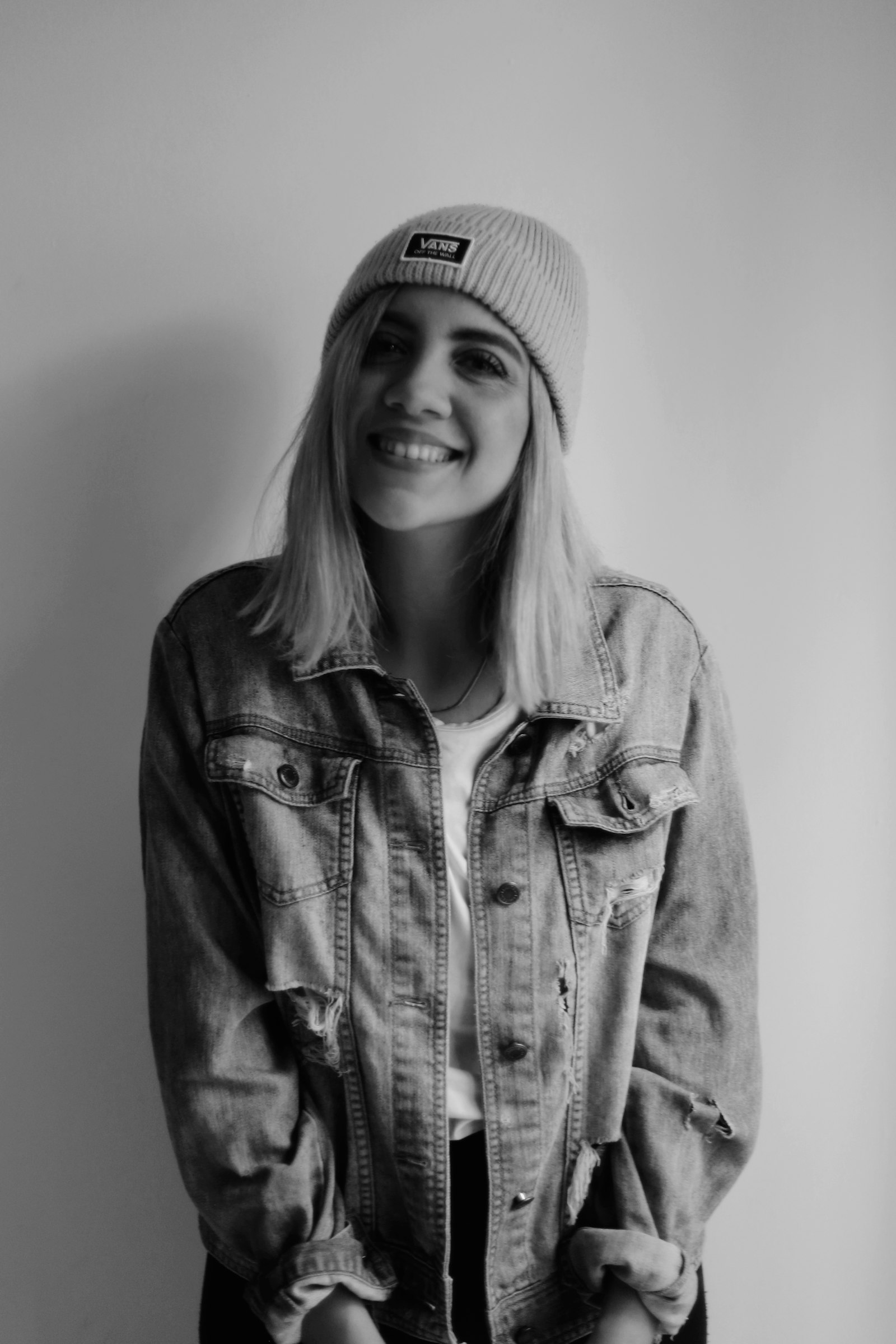 A woman smiling in a denim jacket