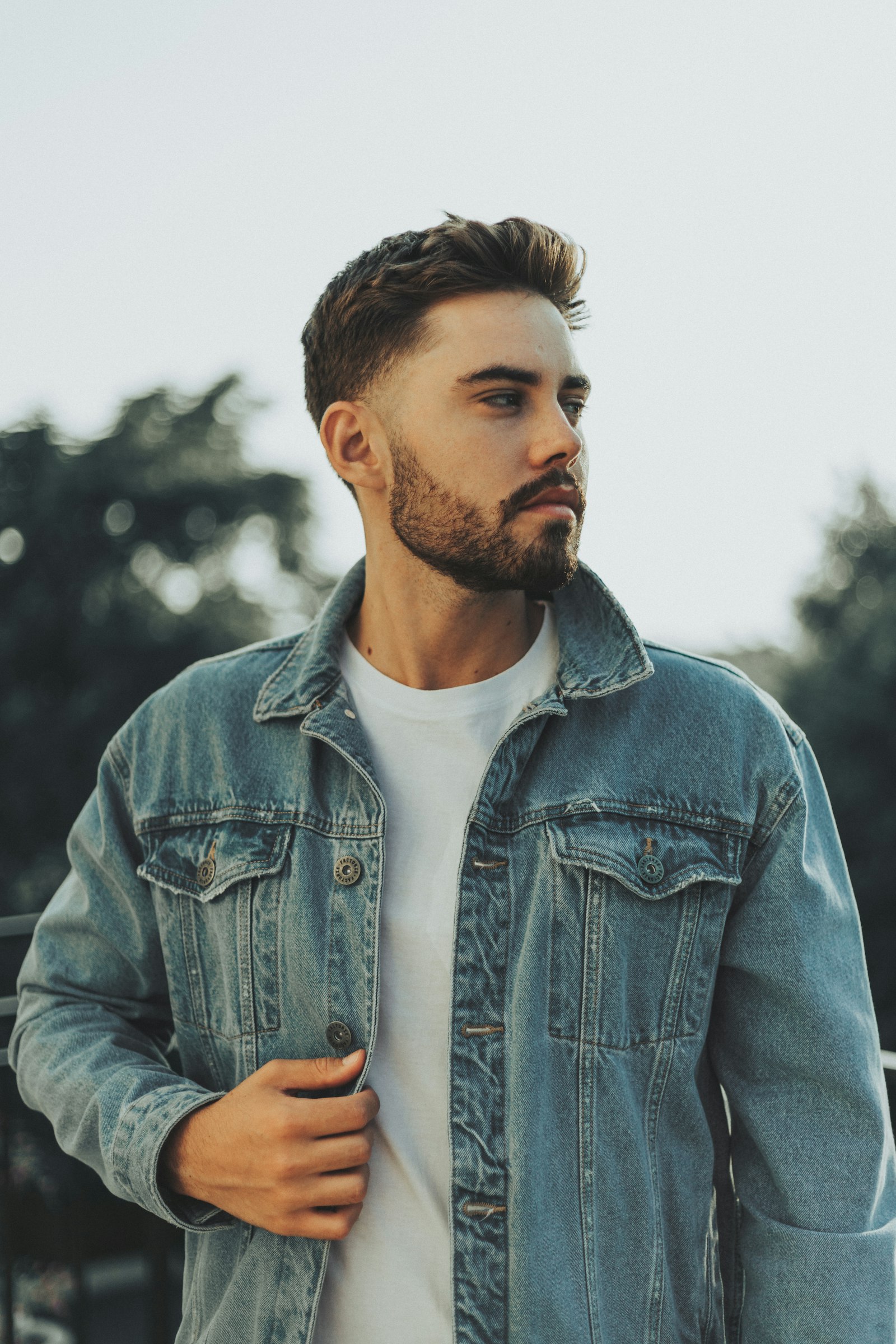 A bearded man wearing a denim jacket