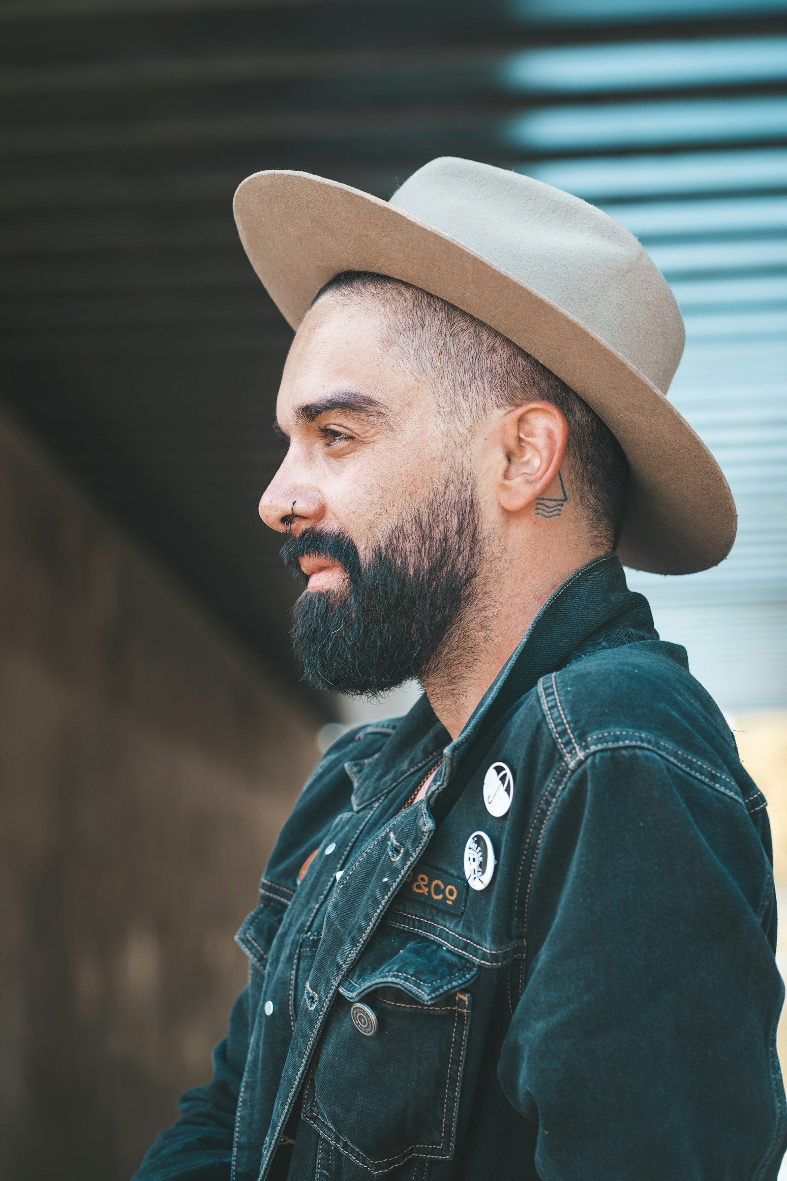 A man in a blue denim jacket and a brown hat